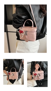 Pink leather box bag with pearl heart charm and metal handle shown in various angles