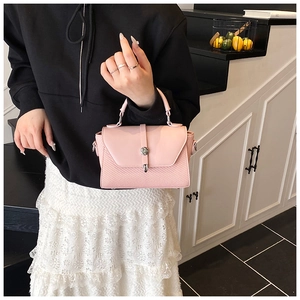 Detail of a light pink mini handbag with smooth leather flap and textured weave base