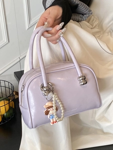 Chic lavender Boston handbag with pearl strap and cartoon charm for stylish women