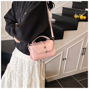 Chic pink crossbody bag with woven texture and top handle shown in a lifestyle setting