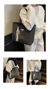 Macro detail of large woven tote bag featuring metal logo plate and tricolor tassel charm