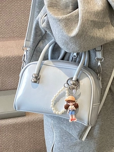 Elegant light blue leather Boston handbag with pearl bracelet and cartoon girl charm