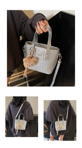Close-up of silver woven bucket bag with fashion lettering and cute bear pendant
