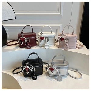 Detail view of stylish box handbags in five colors featuring pearl and heart charms