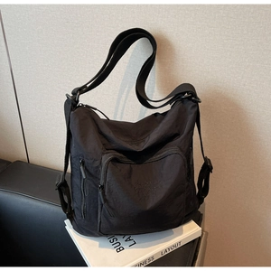 Detail view of water-resistant black nylon fabric and functional side pocket on travel tote