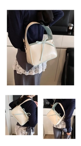 Détail du sac seau crème avec bordure contrastée bleue et nœud décoratif élégant