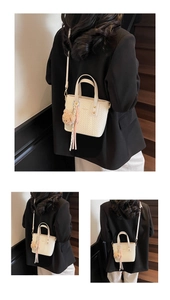 Detail of off-white quilted bucket bag with fashion print and cute bear charm