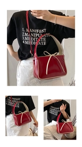Détail du sac seau en cuir verni rouge avec passepoil crème et noeud élégant