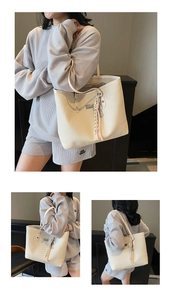 Detail view of cream woven tote bag showing texture, large capacity, and strap details