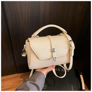 Detail of beige leather and woven straw textures on a chic crossbody small square handbag