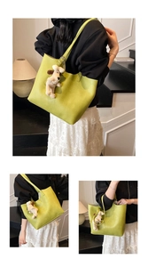 Detail of lime green tote bag with pebble leather texture and cute dog plush charm