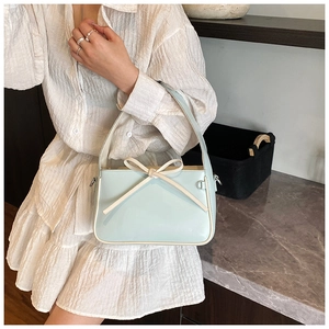 Détail du sac seau bleu clair avec nœud blanc et liseré contrasté sur le bord du sac