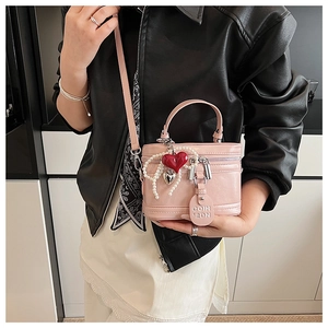 Pink glossy leather mini box bag featuring heart charms and pearl chain detail