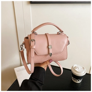 Detail of pink leather and woven crossbody bag with metallic round buckle