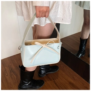 Détail du sac seau bleu clair avec nœud décoratif et anneaux en D métalliques solides
