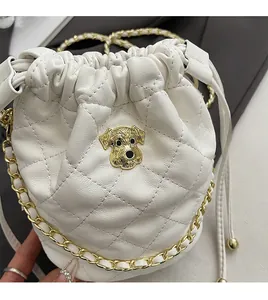 Détail du sac seau blanc matelassé avec logo chiot doré et bandoulière chaîne