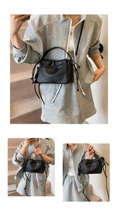 Detail of the black drawstring handbag featuring lychee texture and pleated design