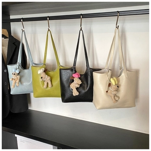 Row of colorful minimalist tote bags hanging on a rack with cute puppy charms
