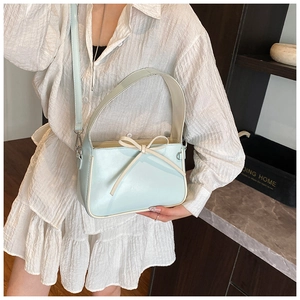 Détail du sac seau bleu clair avec décoration nœud et bandoulière amovible incluse