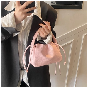 Detail of light pink lychee texture leather handbag with drawstring pleated design