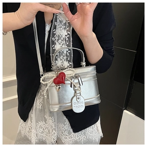 Silver metallic box bag with pearl bow detailing and red heart charm accent