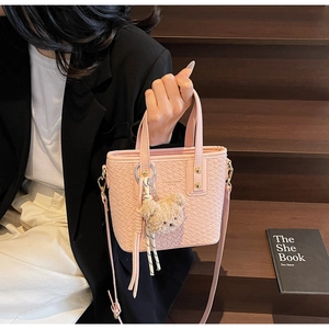 Pink bucket bag with woven texture, golden rivets, and cute plush bear charm detail
