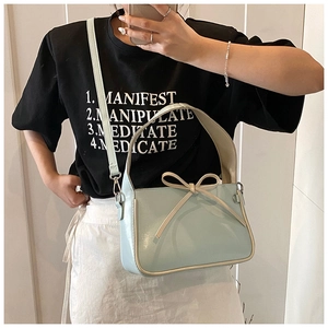 Détail du sac seau en PU bleu clair avec nœud crème et détails de passepoil contrasté