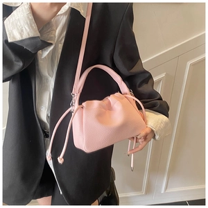 Detail of pink pleated cloud bag with litchi grain texture and silver hardware