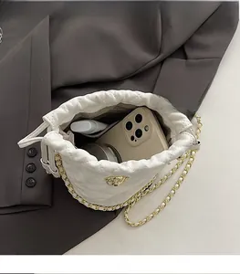 Vue intérieure montrant la capacité du sac seau blanc matelassé avec chaîne dorée
