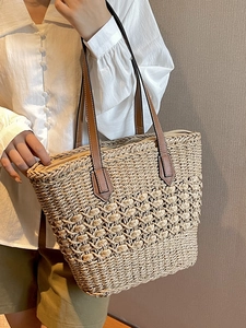 Straw tote bag with brown leather handles and large capacity for beach vacation and leisure