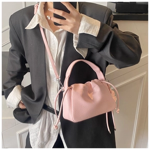Detail of pink pleated handbag with lychee grain texture and drawstring closure
