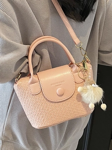 Sac seau rose à texture tissée avec breloque peluche et bandoulière amovible sur tricot