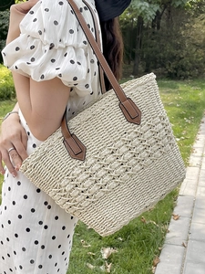 Straw woven tote bag with brown leather straps and beige crochet pattern for summer