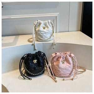 Détails de sacs seau matelassés en blanc, noir et rose avec des bandoulières dorées
