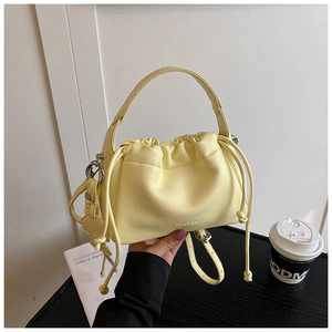 Close-up of light yellow cloud bag featuring lychee texture leather and drawstring closure