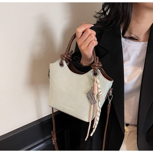 Détail du sac seau vert menthe avec poignée nouée marron et anneaux métalliques chic