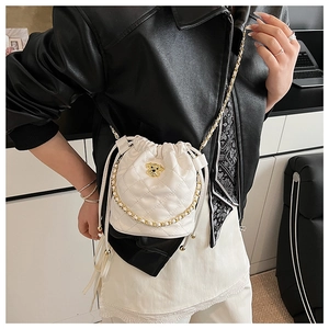 Sac seau matelassé blanc avec logo de chien doré et bandoulière en chaîne sur modèle