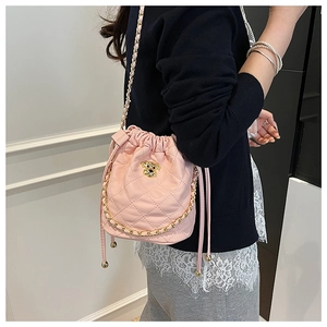 Sac seau matelassé rose avec ornement de chien doré et bandoulière en chaîne tressée