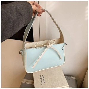 Détail du sac seau bleu clair avec liseré contrasté et un nœud décoratif élégant