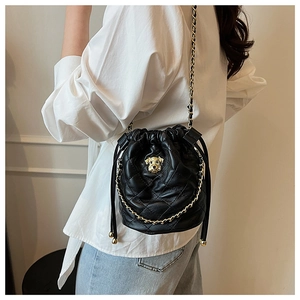 Détail du sac seau noir matelassé avec décoration tête de chien dorée et chaîne