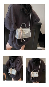 Detail view of silver metallic crossbody bag with woven tassel and thin shoulder strap