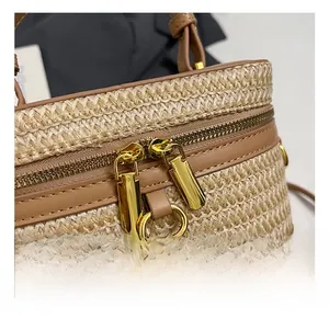 Detailed macro view of woven straw texture with premium brown leather trim and gold zippers