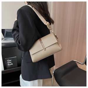 Beige litchi grain shoulder bag with wide canvas strap and brown leather accent detail