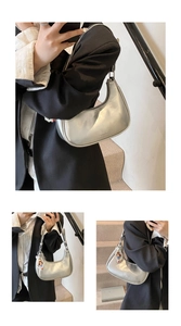 Detail of silver metallic hobo bag with zip closure and cute cartoon character pendant