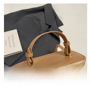 Close-up of the vintage brown leather handle and woven straw texture on the handbag