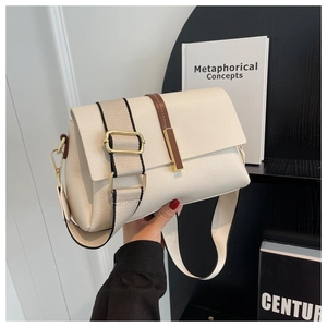 Detail of creamy white lychee leather bag with wide woven strap and gold hardware