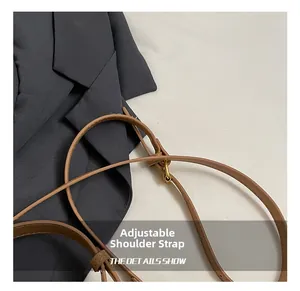 Detailed close-up of brown PU leather adjustable shoulder strap with gold buckle