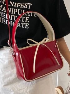 Sac seau en cuir verni rouge avec nœud blanc et bandoulière amovible élégante