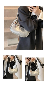 Detailed close-up of a silver crescent underarm bag with elegant pearl and doll charms