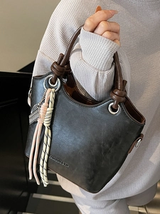 Sac à main minimaliste gris anthracite avec poignées brunes et pompon tissé élégant